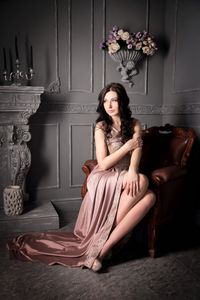 vecteezy_woman-sitting-in-armchair-in-long-beige-dress-luxury_1014739