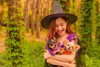 vecteezy_young-girl-in-halloween-costume-holding-two-chihuahua_3023710